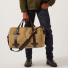 Filson Rugged Twill Duffle Bag Medium Tan carrying in hand